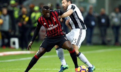 Bek Juventus, Andrea Barzagli (kanan) berebut bola dengan gelandang AC MIlan, M'baye Niang pada laga Serie A di stadion San Siro, Ahad (20/10) dini hari WIB. Pada laga itu, Juventus kalah tipis 0-1.