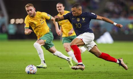 Bek kanan Australia Nathaniel Atkinson (kiri) menjaga pergerakan penyerang Prancis Kylian Mbappe.