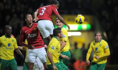 Bek kiri Manchester United, Patrice Evra, menyundul bola disaksikan rekannya, Chris Smalling, dan para pemain Norwich City. Pertandingan yang berlangsung di Carrow Road, Ahad (18/11) dini hari itu dimenangkan Norwich 1-0.