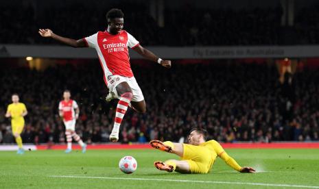 Bek LIverpool Andy Robertson (kanan) mencoba menekel pemain Arsenal Bukayo Saka.