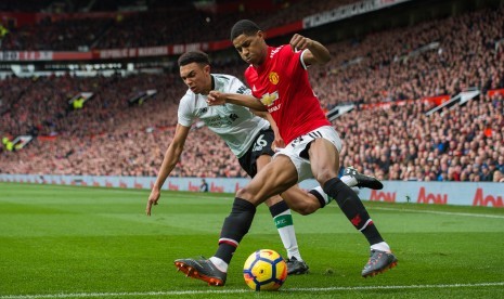 Bek Liverpool, Trent Alexander-Arnold (kiri) berebut bola dengan striker Manchester United, Marcus Rashford pada laga Liga Primer Inggris di Old Trafford, Sabtu (19/3).