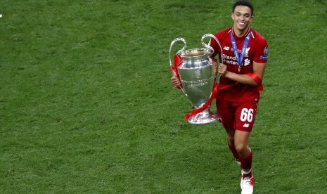 Bek Liverpool, Trent Alexander-Arnold membawa trofi Liga Champions.