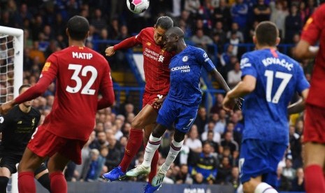 Bek Liverpool, Virgil van Dijk (tengah) berduel di udara dengan gelandang Chelsea, N'golo Kante pada laga Liga Primer Inggris, di Stamford Bridge, London, Ahad (22/9).