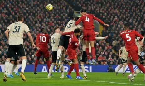 Bek Liverpool Virgil van Dijk (tengah) mencetak gol ke gawang Manchester United lewat sundulan pada laga lanjutan Liga Primer Inggris di Anfield, Liverpool, Ahad (19/1).