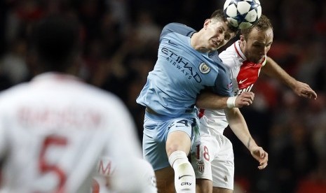 Bek Manchester City, John Stones berduel udara dengan striker AS Monaco, Valere Germain pada laga Liga Champions di Stade Louis II, Kamis (16/3) dini hari WIB. City akhirnya tersingkir.