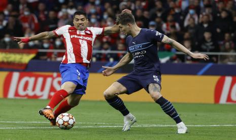 Bek Manchester City, John Stones (kanan) mengawal aksi striker Atletico Madrid, Luis Suarez di Wanda Metropolitano, Kamis (14/4/2022).