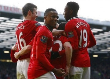 Bek Manchester United, Patrice Evra (tengah), melakukan selebrasi bersama rekan saat mengalahkan Bolton Wanderers 3-0 di laga Liga Primer di Old Trafford, Manchester, Sabtu (14/1).