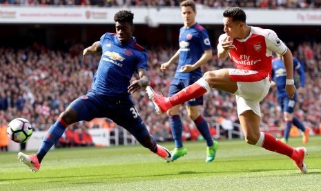 Bek muda Manchester United Axel Tuanzebe (kiri) saat menahan bola penyerang Arsenal Alexis Sanchez.