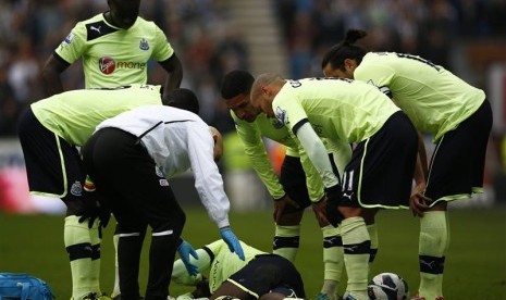 Bek Newcastle Massadio Haidara tergeletak di lapangan usai mendapatkan tekel dari gelandang Wigan Callum McManaman pada laga yang berlangsung, Ahad (18/3) malam di DW Stadium.