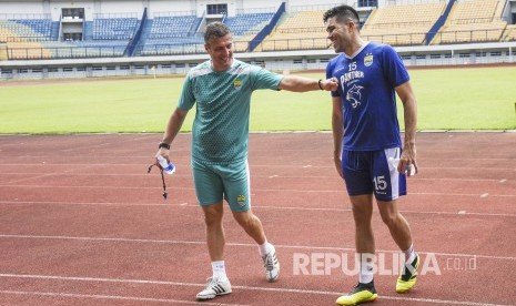 Bek Persib Bandung Fabiano Beltrame (kanan) bercengkerama dengan pelatih Persib Bandung Miljan Radovic (kiri) seusai sesi latihan di Stadion Gelora Bandung Lautan Api, Kota Bandung, Ahad (24/3).