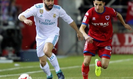 Bek Real Madrid Dani Carvajal (kiri) menggiring bola dengan kawalan gelandang Numancia Pere Milla pada babak 16 besar Piala Raja di Stadion Los Pajaritos, Soria, 4 Januari 2018. 