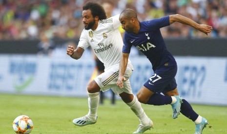 Bek Real Madrid Marcelo (kiri) menjaga gelandang serang Tottenham Hotspur Lucas Moura.