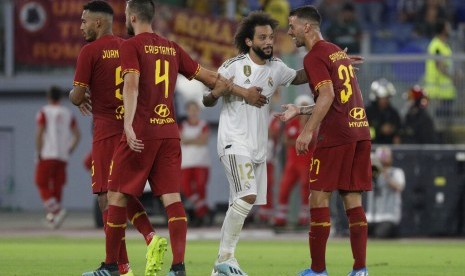 Bek Real Madrid, Marcelo (tengah) di antara pemain AS Roma pada laga uji coba, Ahad (11/8). 