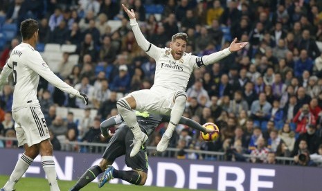 Bek Real Madrid, Sergio Ramos (kanan), melompat berebut bola dengan pemain Real Sociedad, Asier Illarramendi (belakang), dalam laga La Liga Spanyol di Stadion Santiago Bernabeu, Madrid, Spanyol, Ahad (6/1). 