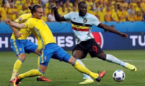 Bek Swedia Emil Forsberg menahan tendangan penyerang Belgia Romelu Lukaku. 