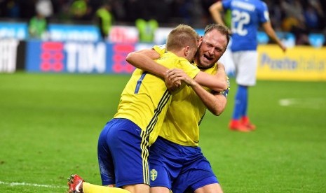 Bek Timnas Swedia, Andreas Granqvist (kanan) dan Sebastian Larsson merayakan keberhasilan timnya lolos ke putaran final Piala Dunia 2018 usai menahan imbang Italia 0-0 di leg kedua babak kualifikasi Zona Eropa di Stadion Giuseppe Meazza, Milan, Italia, Senin (13/11). 