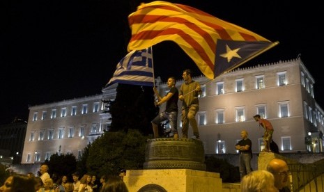  Bendera Estelada atau kelompok separatis Katalonia dan bendera Yunani dikibarkan depan gedung parlemen di Athena (29/6). Masyarakat Yunani terkena dampak krisis yang berkepanjangan mengakibatkan penutupan bank dan antrian panjang di supermarket.