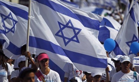 Bendera Israel dikibarkan warga. Israel telah mengonfirmasi satu kasus Omicron pada turis perempuan dari Malawi. Ilustrasi.