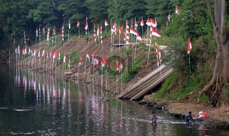 Bendera merah putih terpasang di pinggiran kali Ciliwung kawasan Pasar Rebo, Jakarta Timur, Rabu (12/8).