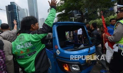 Bentrokan terjadi antara Go-jek dengan supir taxi yang tengah melakukan aksi menutup jalan di Jalan MH.Thamrin, Jakarta Pusat, Selasa (22/3). 