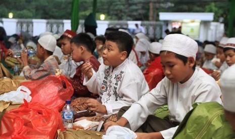 Berbagi kebahagiaan bersama anak yatim.