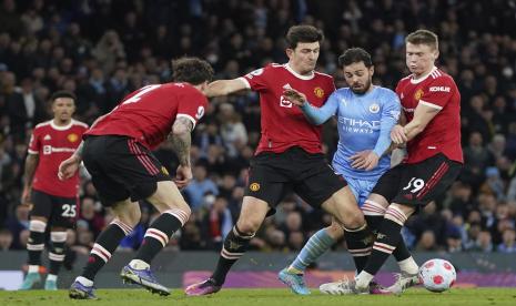 Bernardo Silva dari Manchester City, kedua kanan, berebut bola dengan Scott McTominay dari Manchester United, kanan, Harry Maguire dari Manchester United selama pertandingan sepak bola Liga Premier Inggris antara Manchester City dan Manchester United, di stadion Etihad di Manchester, Inggris, Ahad, Maret 6, 2022.