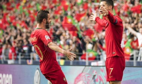 Bernardo Silva (kiri) dan Cristiano Ronaldo merayakan kemenangan timnas Portugal.