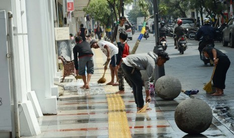 Bersihkan Braga: Sejumlah warga membersihkan trotoar Jl Braga, Kota Bandung, Rabu (22/4). Lokasi tersebut pada puncak Konferensi Asia Afrika (KAA) 24 April 2015 akan diramaikan oleh awak media dari dalam dan luar negeri.(Edi Yusuf/Republika)