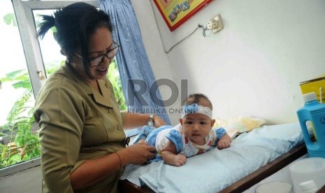 Bidan memeriksa tumbuh kembang anak di Puskesmas Cawang, Jakarta Timur, Rabu (16/12). 