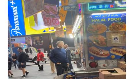 Bill Gates berdiri di depan gerobak penjual hot dog halal di Times Square New York, Amerika Serikat. 