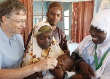 Bill Gates memberikan vaksin kepada seorang anak di Pusat Kesehatan Komunitas, Nigeria