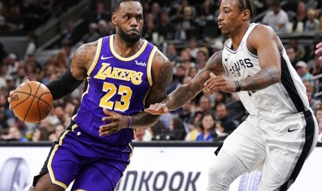 Bintang Los Angeles Lakers LeBron James (kiri) berusaha melewati pemain San Antonio Spurs DeMar DeRozan.