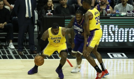 Bintang Los Angeles Lakers LeBron James membawa bola.