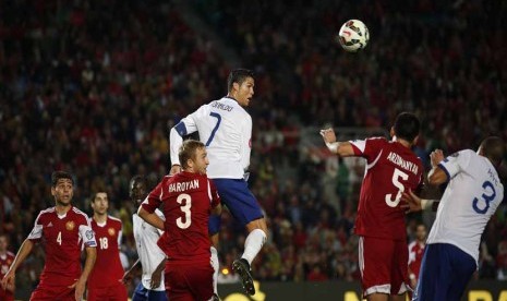 Bintang Timnas Portugal, Cristiano Ronaldo (tengah), melepaskan sundulan di tengah kepungan pemain Armenia di laga Grup I kualifikasi Piala Eropa 2016 di Stadion Algarve, Faro, Jumat (14/11). 