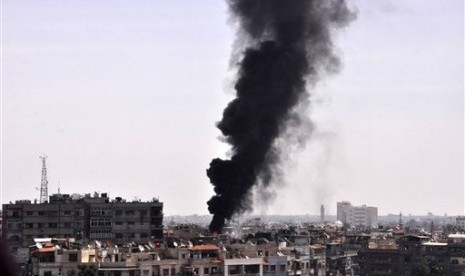 Black smoke rises from the rooftop of a building that was, according to SANA, attacked by a mortar shelled by the Syrian rebels in Damascus, Syria, Saturday, April 5, 2014.