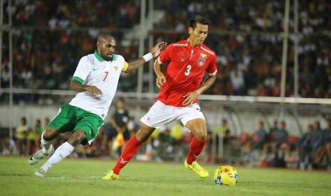 Boaz Solossa (kiri) berupaya menekan pemain Myanmar dalam laga uji coba di Yangon, Jumat (4/11).