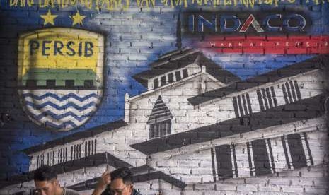 Bobotoh alias pendukung Persib berbincang di depan mural Persib di Bandung, Jawa Barat, Selasa (2/10).