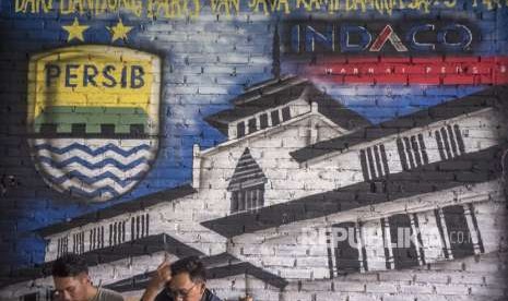 Bobotoh alias pendukung Persib berbincang di depan mural Persib di Bandung, Jawa Barat, Selasa (2/10). 