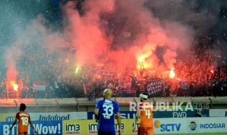  Bobotoh menyalakan flare saat pertandingan Persib melawan Pusamania Borneo FC pada pertandingan Indonesia Soccer Championship 2016 di Stadion Si Jalak Harupat, Kabupaten Bandung, Rabu (14/12).