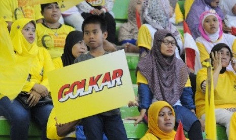 Bocah bersama ibunya mengikuti kampanye terbuka Partai Golkar di Gedung Olah Raga (GOR) Ciracas, Jakarta, Selasa (18/3).