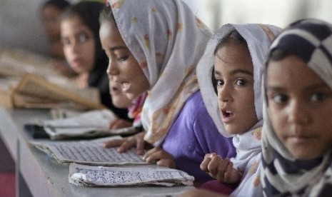 Bocah-bocah Pakistan ini tengah belajar menghapal Alquran di sebuah madrasah di Islamabad.