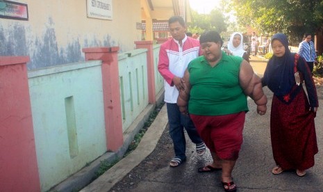 Bocah penderita obesitas ekstrem asal Karawang, Arya Permana, (kanan) diantar orang tuanya ke Sekolah Dasar Negeri Cipurwasari, Kampung Pasir Pining, Desa Cipurwasari, Kecamatan Tegalwaru, Karawang, Jabar, Senin (18/7).