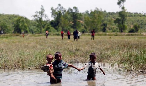 Bocah pengungsi Rohingya melintasi rawa dalam upayanya mengungsi ke wilayah Bangladesh.