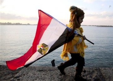 Bocah Mesir, pemrotes anti-Mubarak, membawa bendera Mesir di Alexandria.