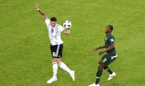 Bola menyentuh tangan bek Argentina Marcos Rojo saat berada dalam tekanan pemain Nigeria Odion Ighalo.