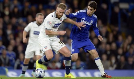 Bolton Wanderers' Matt Mills fights for the ball with Chelsea's Oscar (R) during the English League Cup soccer match at Stamford Bridge in London September 24, 2014.