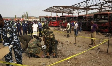 Bomb experts gather evidence in a crater that was caused by a bomb blast explosion at Nyanyan, Abuja April 14, 2014.