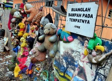 Boneka bekas digantung di pagar sekitar kawasan pintu air Manggarai, Jakarta, Selasa (21/2). (Republika/Edwin Dwi Putranto)