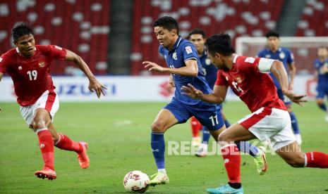  Bordin Phala dari Thailand, tengah, menguasai bola melewati Fachruddin Aryanto dari Indonesia pada pertandingan sepak bola leg pertama final AFF Suzuki Cup 2020 antara Indonesia dan Thailand di Singapura, Rabu, 29 Desember 2021.