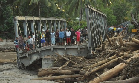 Boyangtongo bridge is cut in the middle as flash floods hit the river in Parigi Moutong, Central Sulawesi, on Saturday night.    